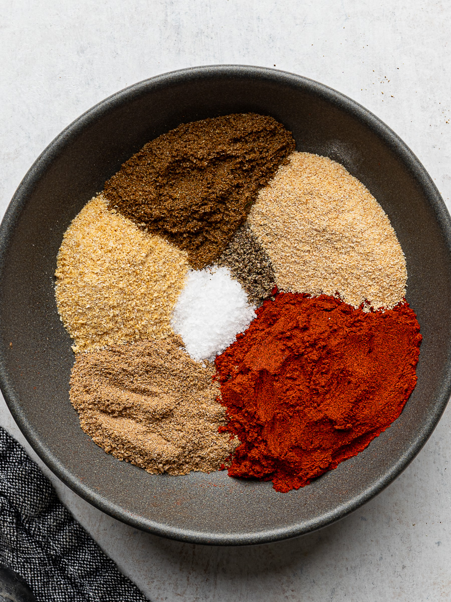 Individual dried spices prepared in a grey bowl.