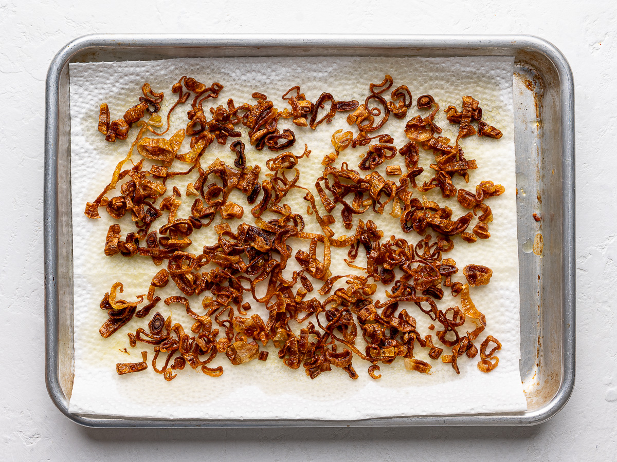 Draining excess oil of Crispy fried shallots on paper towels. 