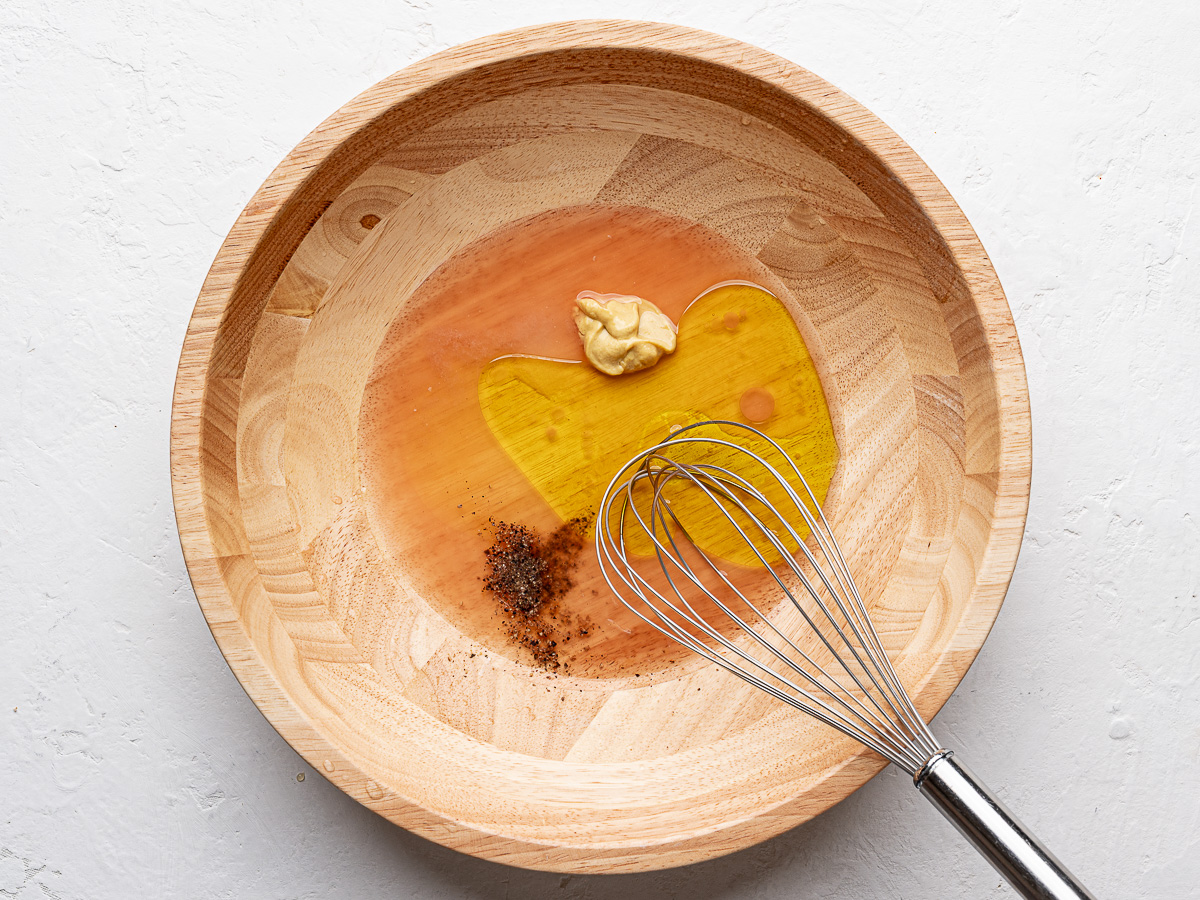 Salad dressing ingredients in wooden bowl. 