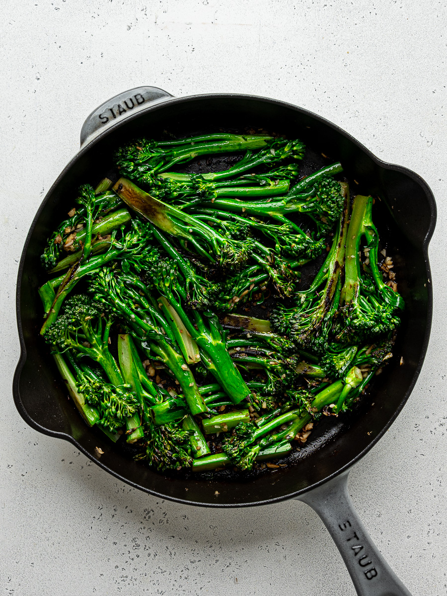 Cooked broccolini stalks in skillet. 