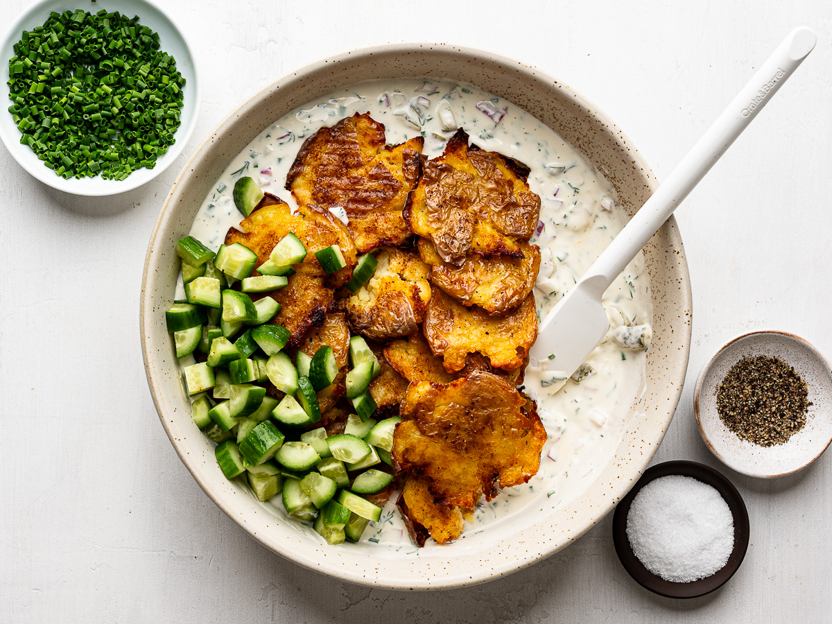 Crispy smashed potatoes tossed with creamy dressing and diced cucumbers.