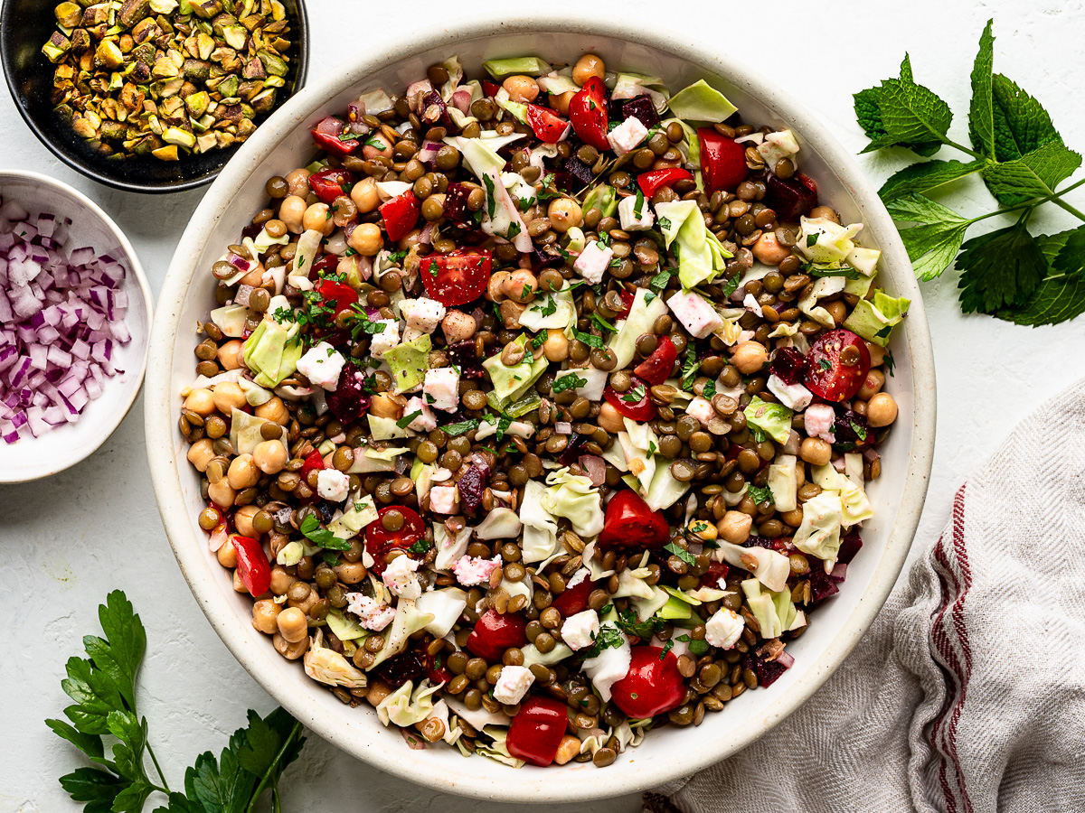 Salad ingredients mixed in white serving bowl.