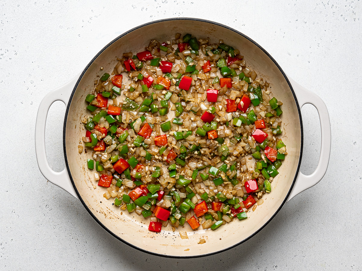 Diced vegetables sautéed in skillet.