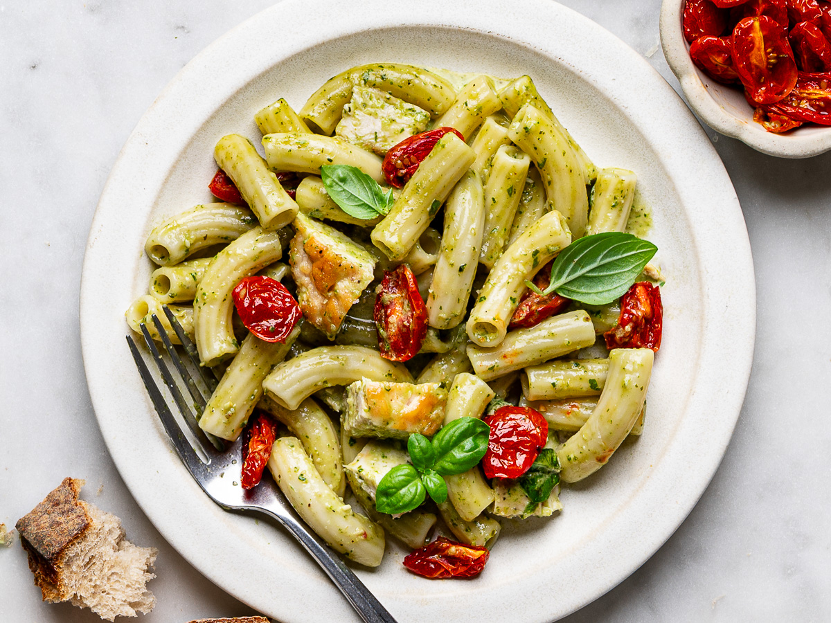 Creamy chicken pesto pasta served on a white plate.