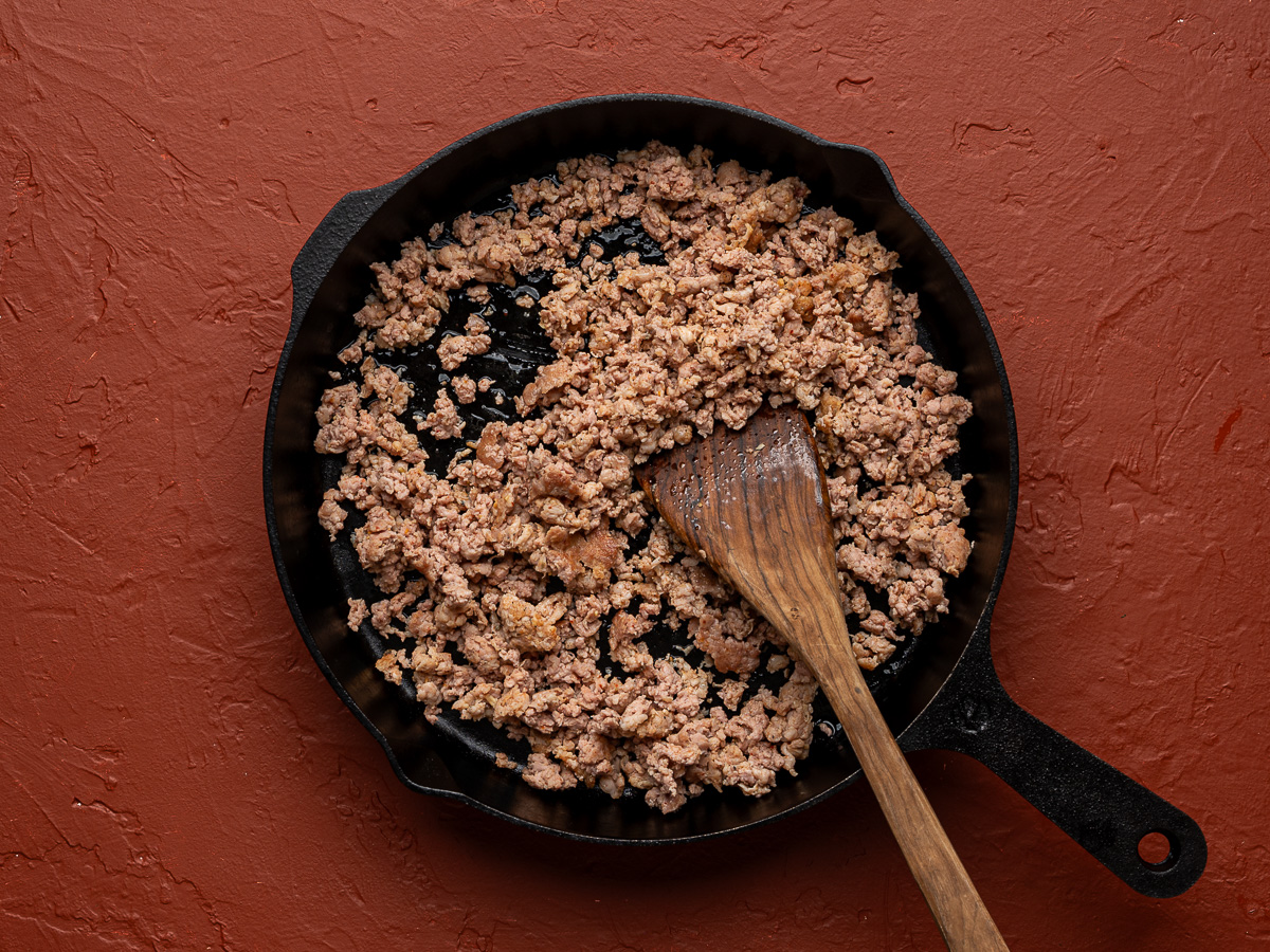 Browned sausage in black skillet.