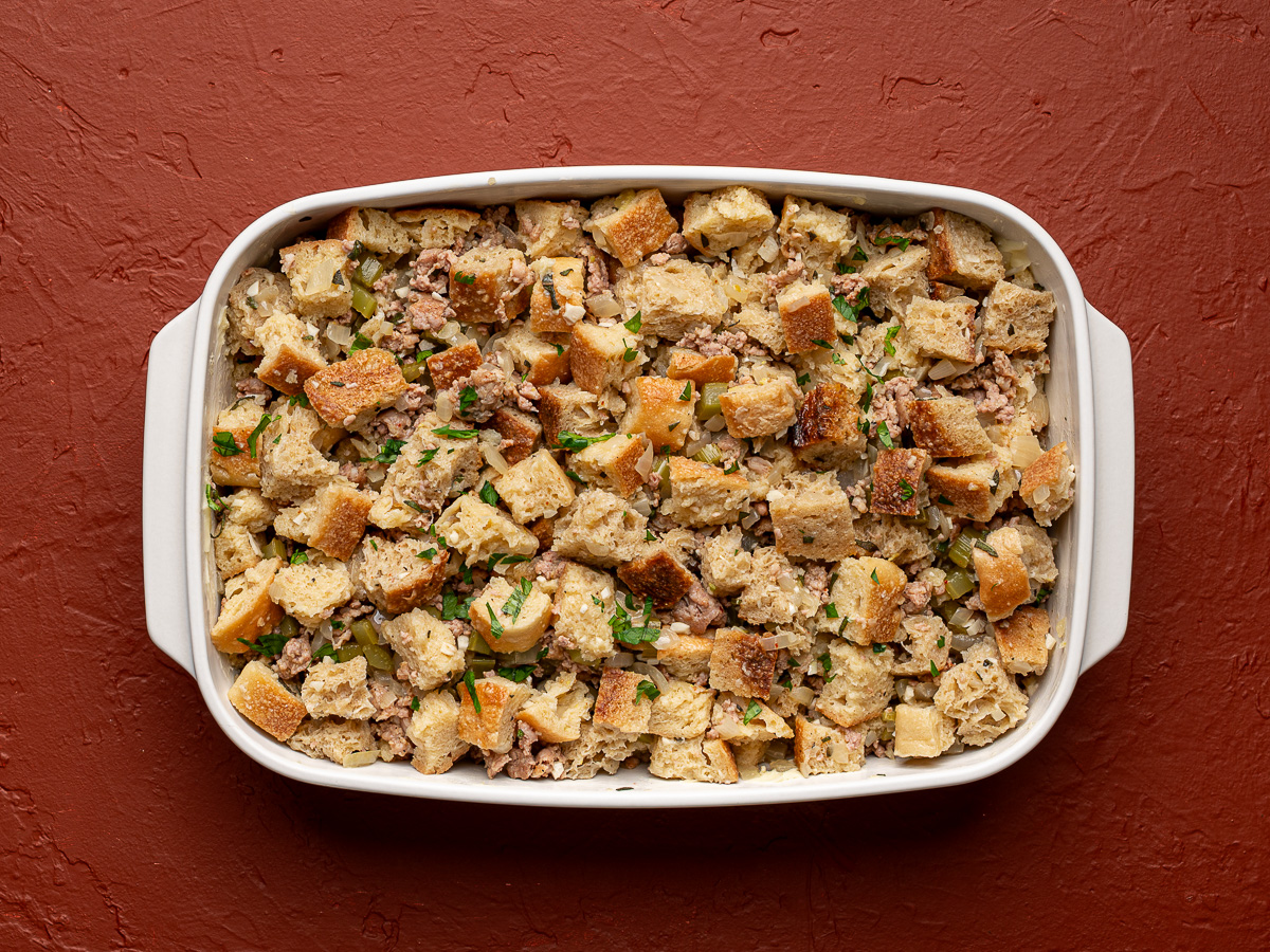 Unbaked stuffing in white baking dish.