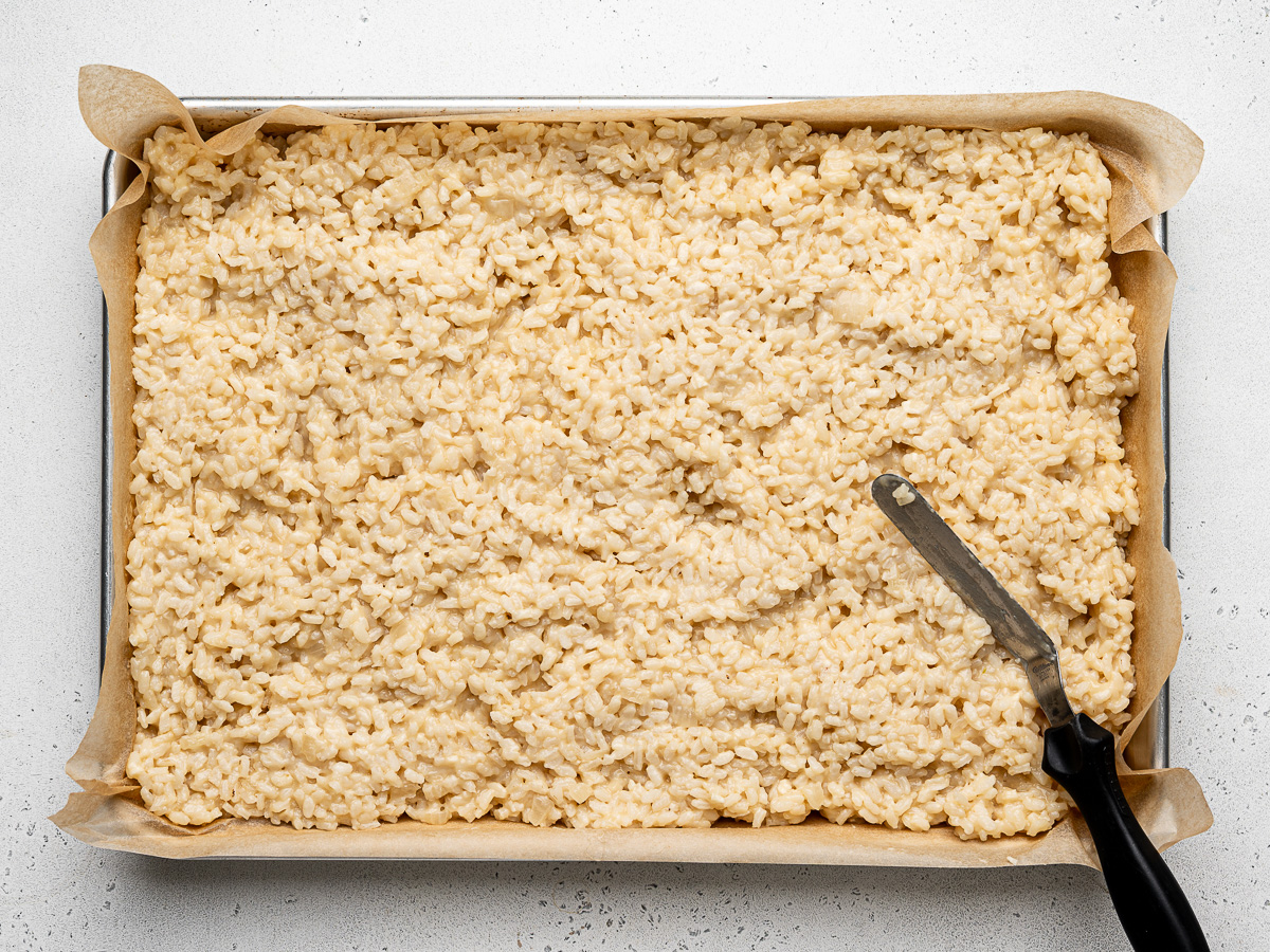 Cooked rice spread out in baking sheet to cool.