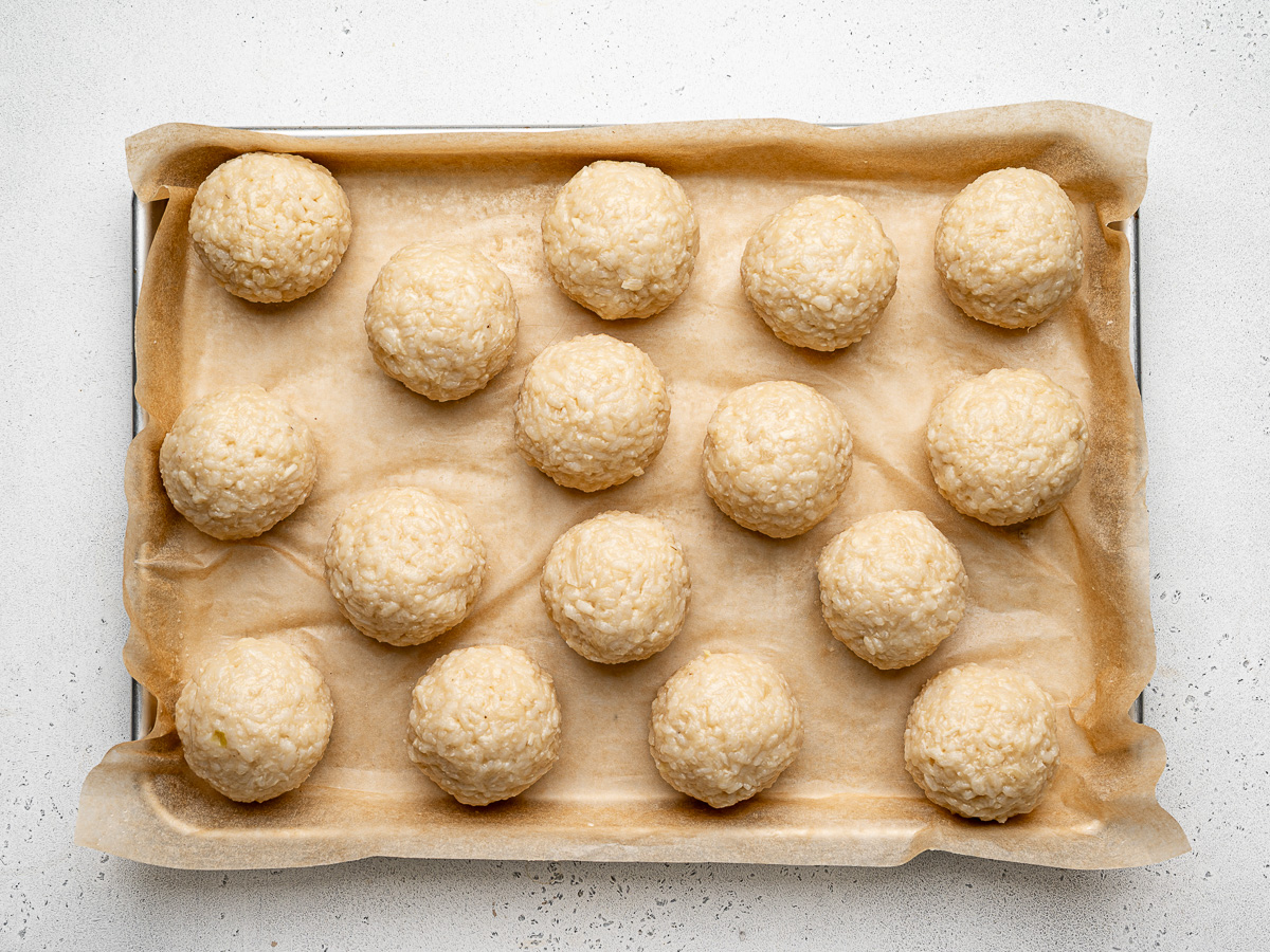 Shaped rice balls on baking sheet.