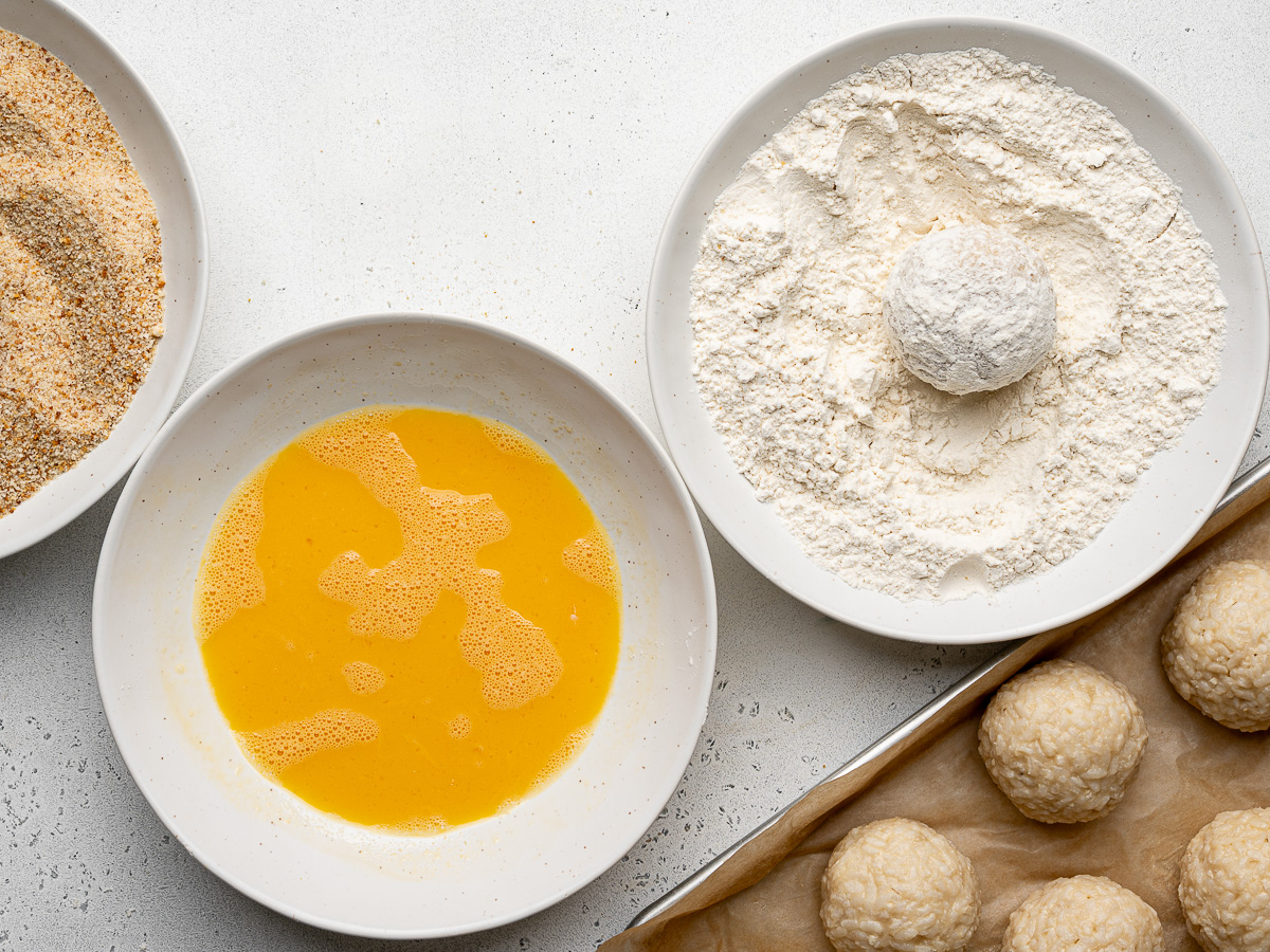 Coating rice ball in flour.