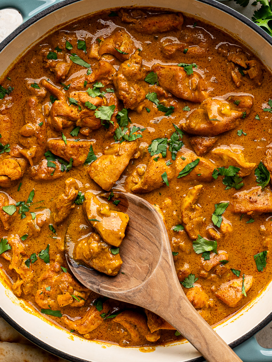Close-up of creamy coconut chicken curry garnished with cilantro, showing the rich, flavorful sauce and tender chicken pieces.