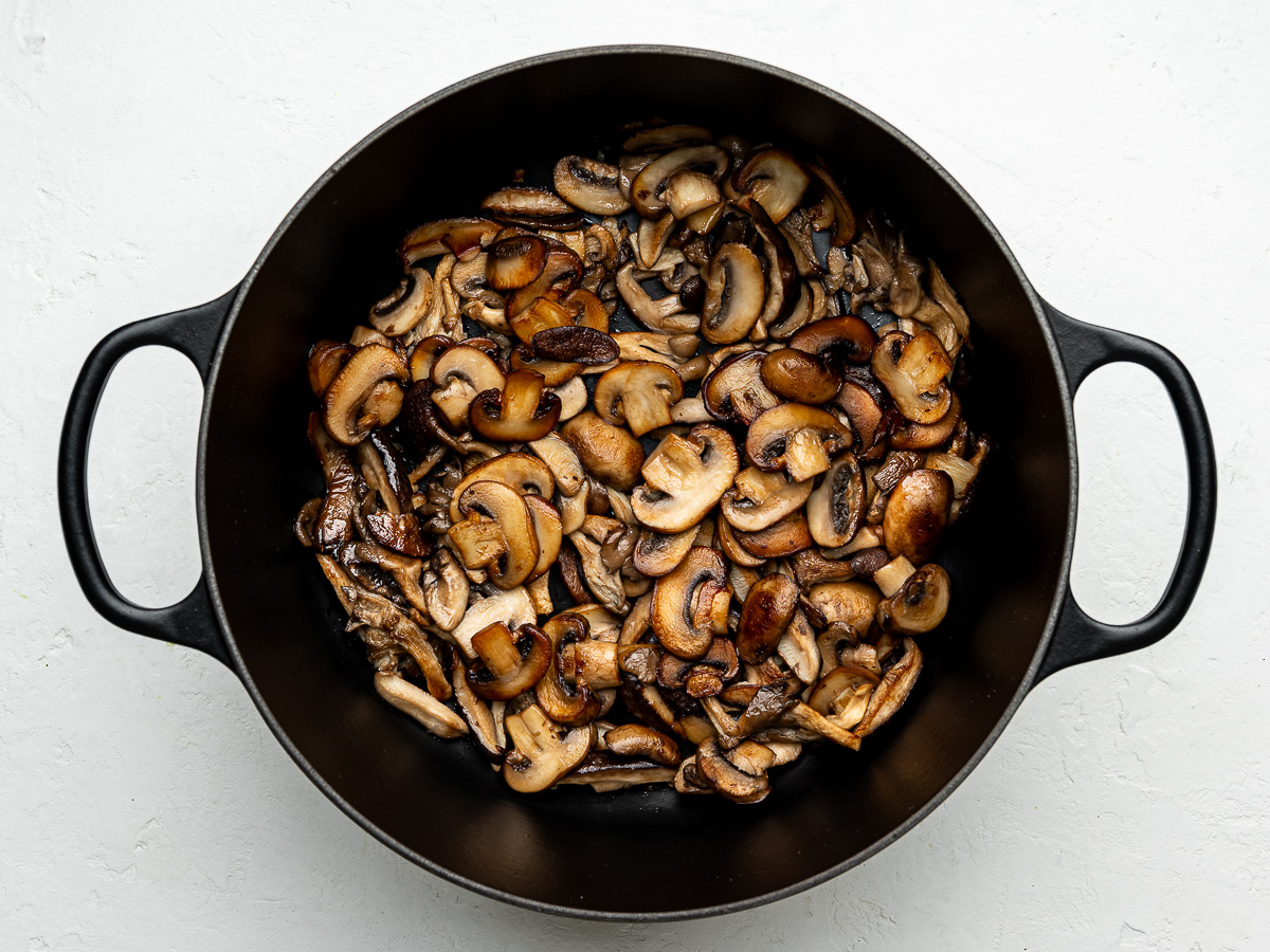 Mushrooms browning in a pot with butter and olive oil for creamy mushroom soup.