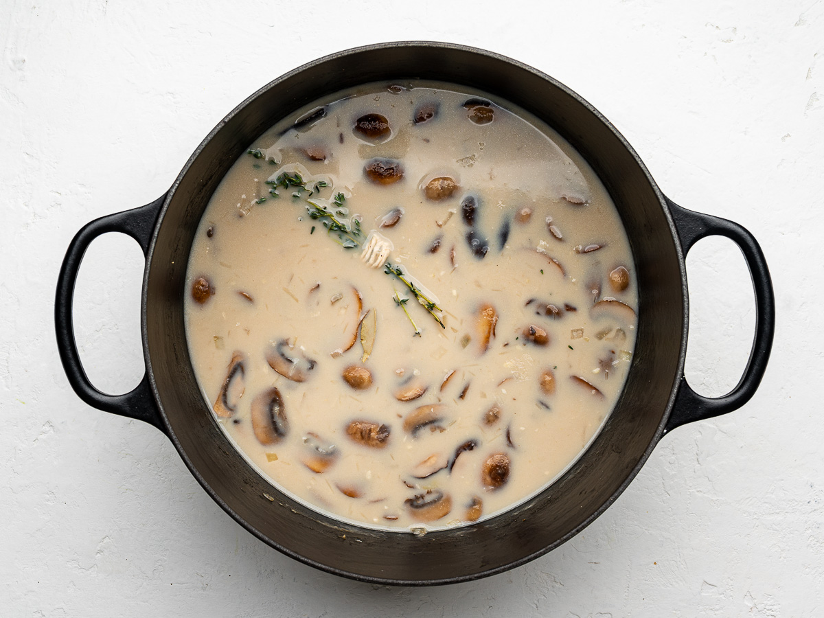 Broth and milk added to mushrooms to create creamy mushroom soup base.