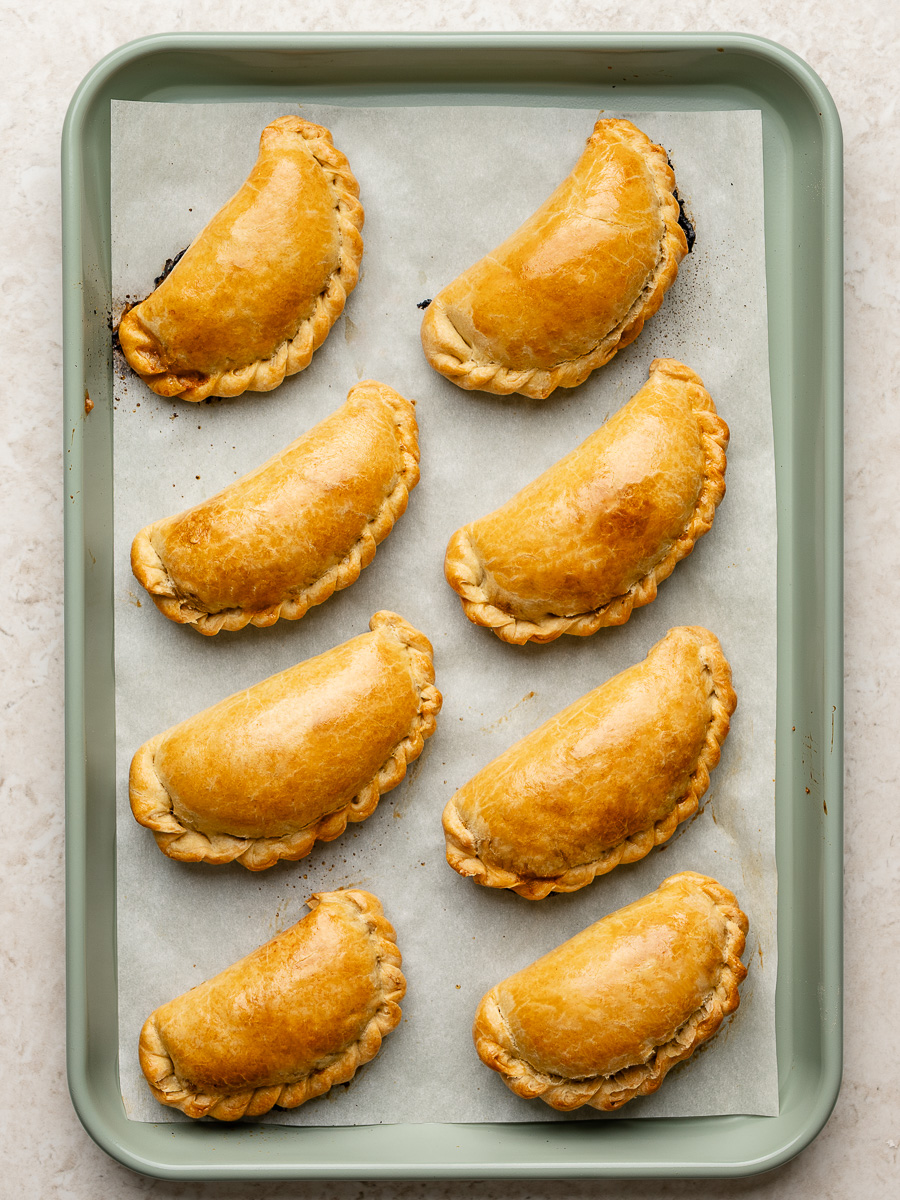 Baked empanadas on baking sheet with rope seal.