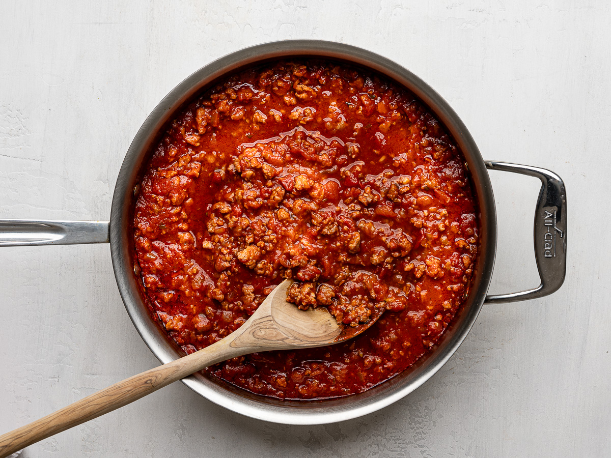 Cooked sausage ragù in stainless steel skillet.