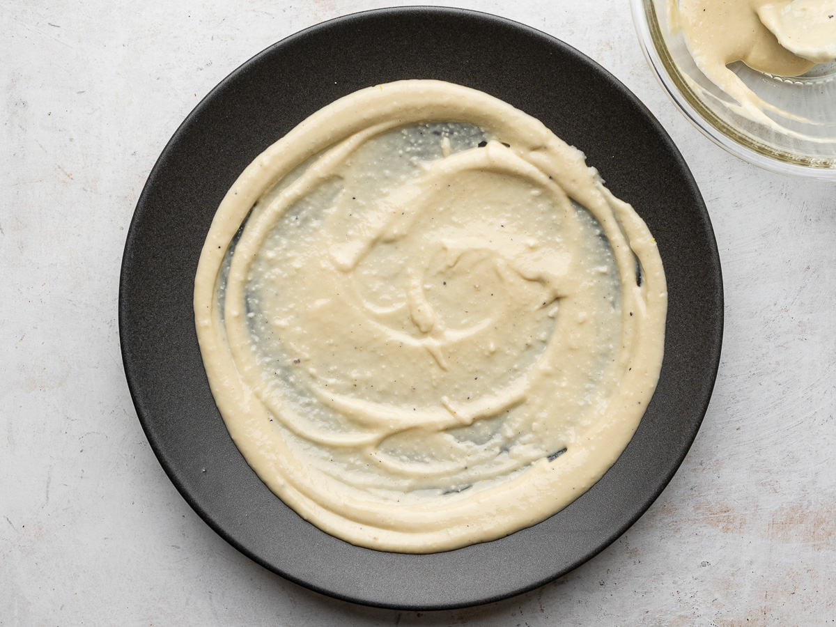 A thick layer of Caesar dressing spread out on a tray platter.