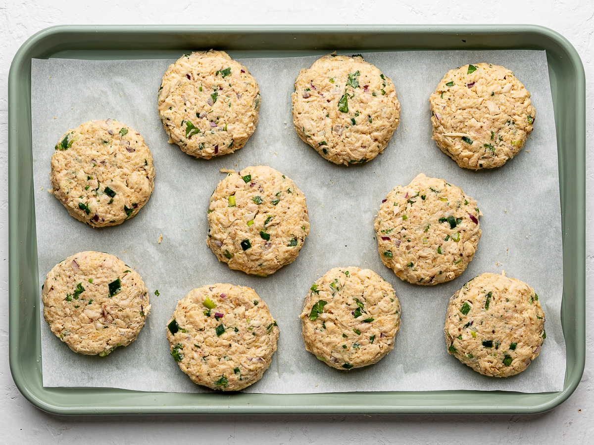 Un-cooked shaped patties on sheet pan.