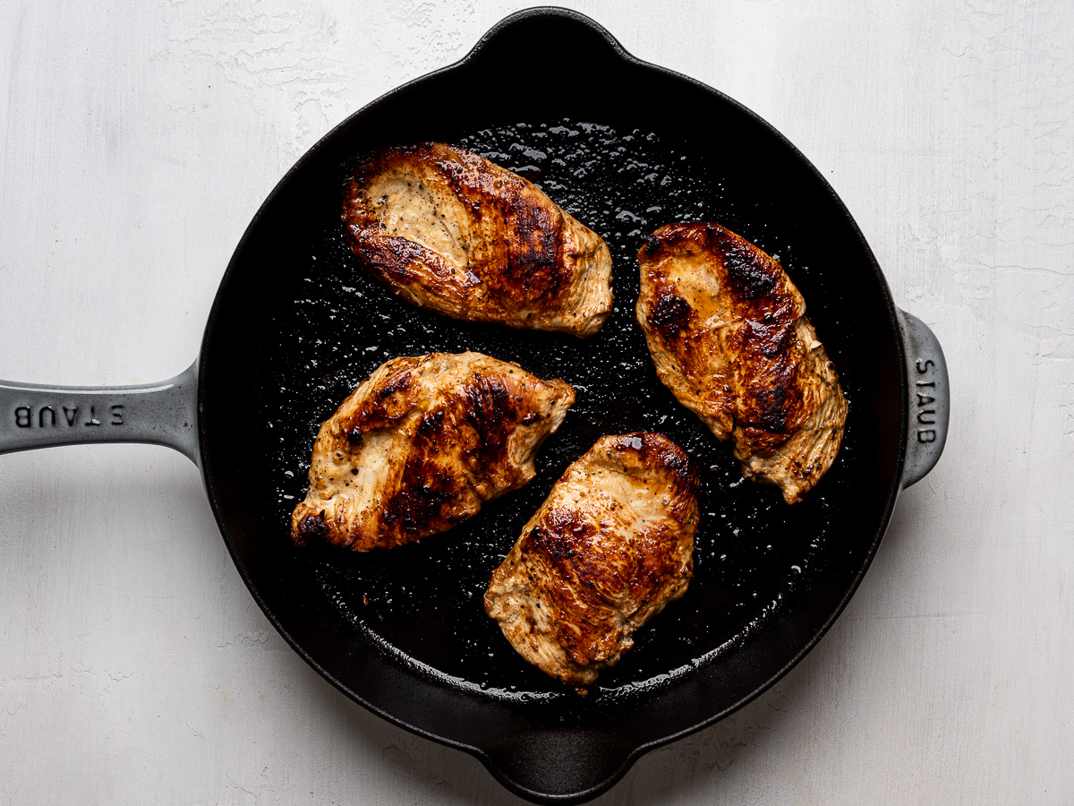 4 chicken breasts pan-fried in a skillet.