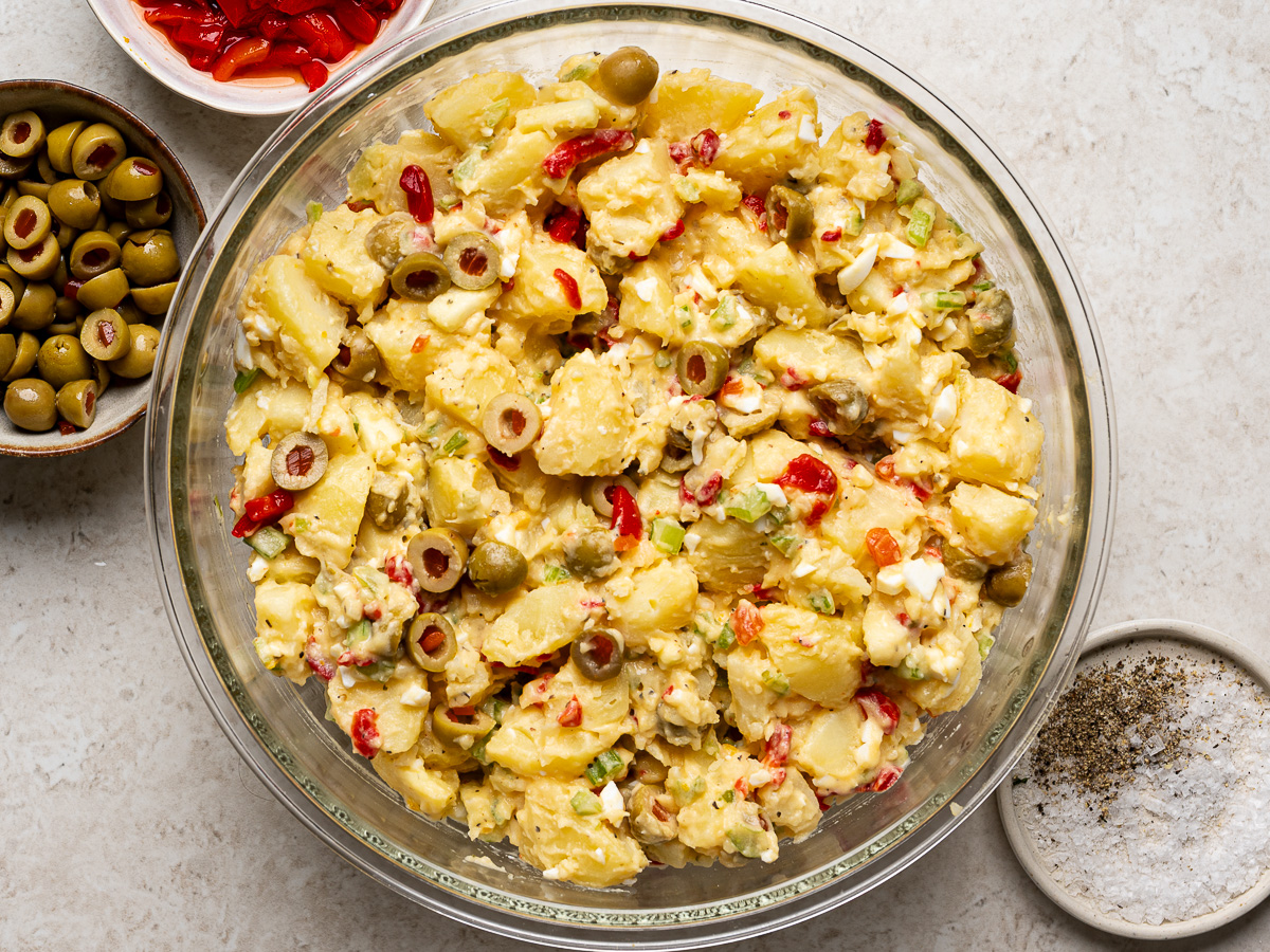 Potato salad tossed in mixing bowl.