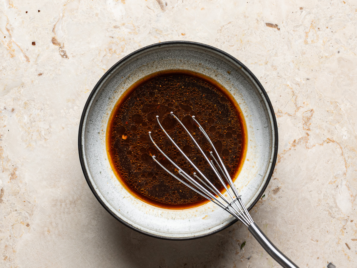 Sauce mixed in a bowl with a small whisk.