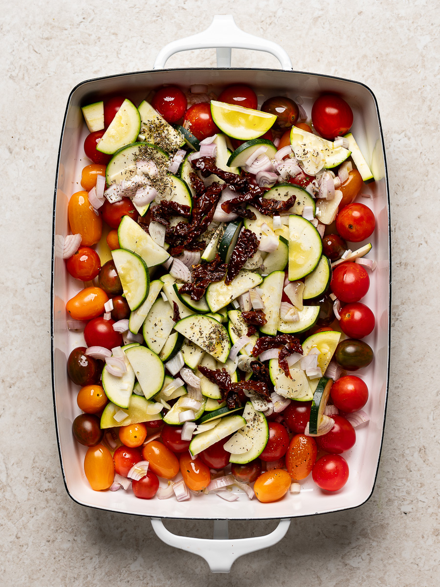 Cherry tomatoes, sliced zucchini, sundried tomatoes, shallots and garlic combined in baking dish.