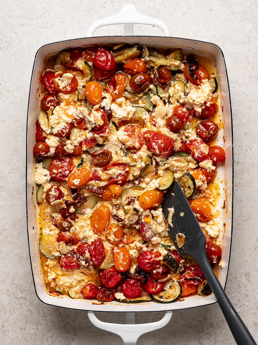 Creamy baked feta mixed in with all the baked veggies in the baking dish.