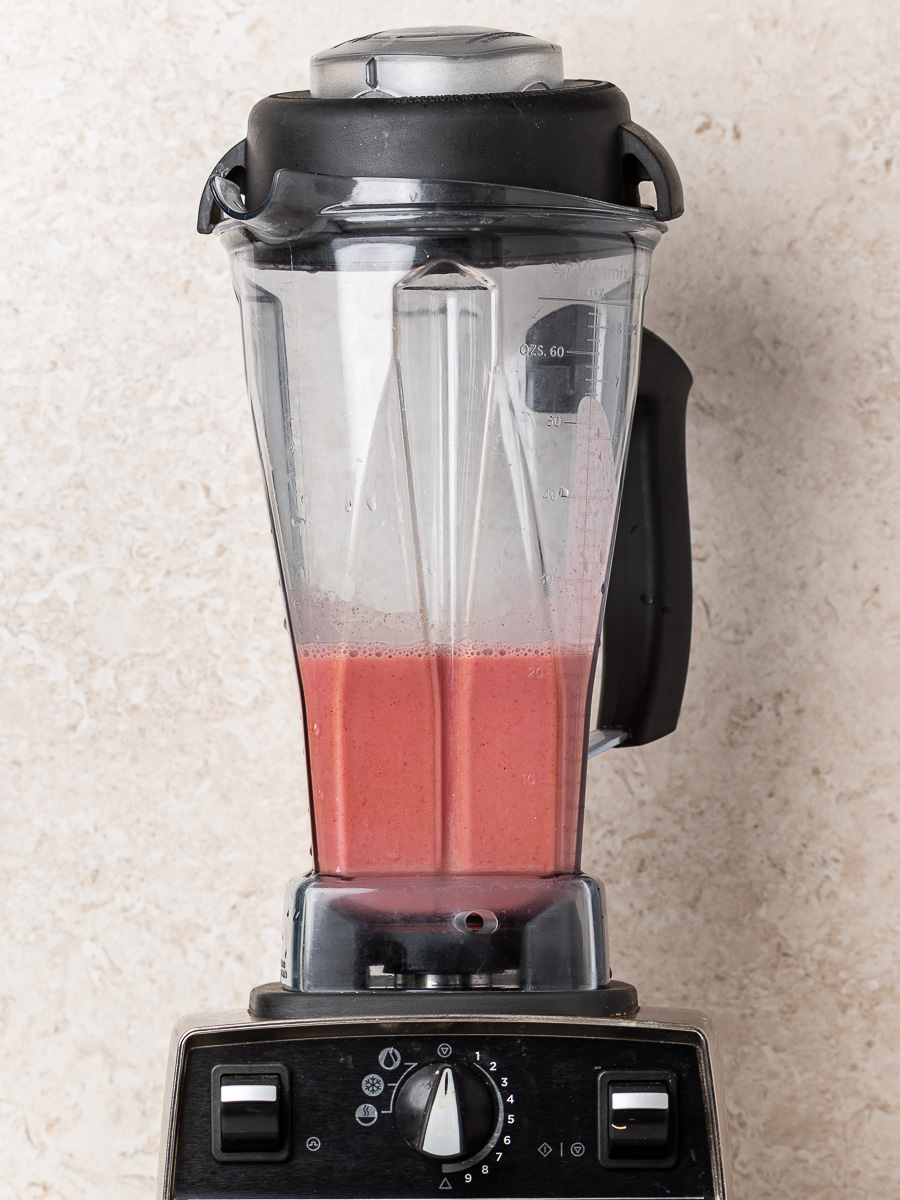 Smooth blended strawberry and milk mixture in a blender for strawberries and cream chia pudding.