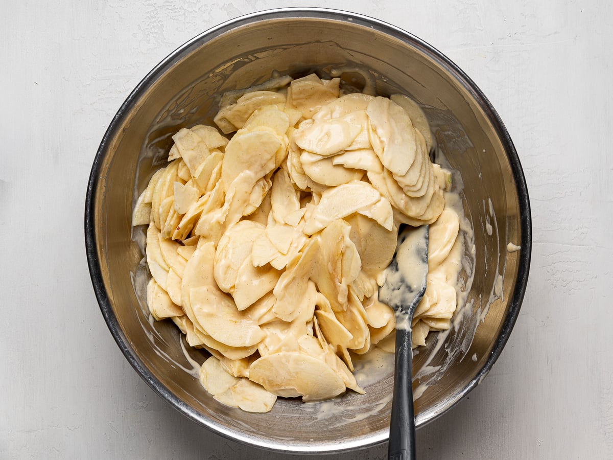 Tossing the apple slices with batter in mixing bowl.