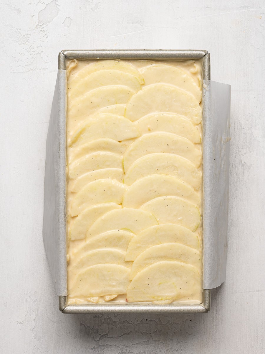 A top layer of apple slices in loaf pan arranged in a scaled pattern.