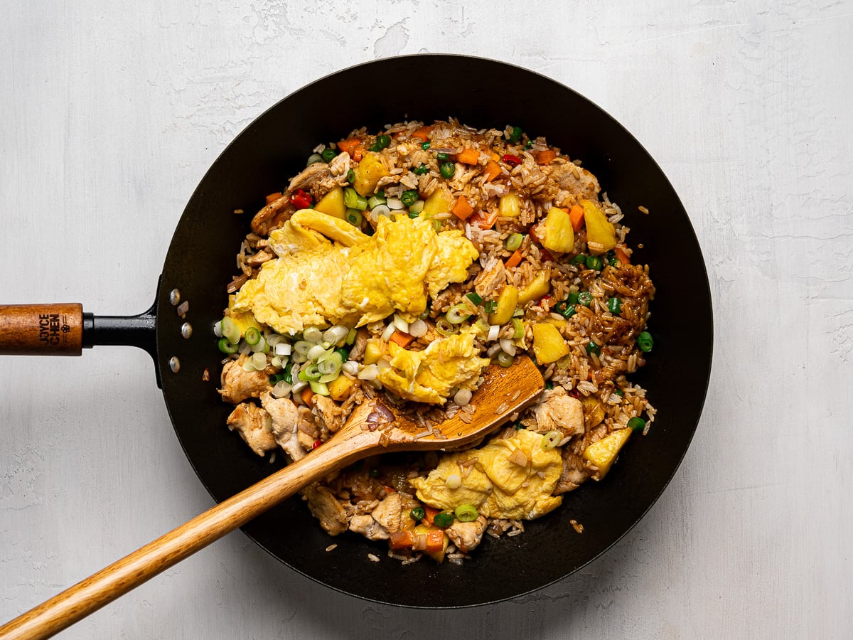 Cooked chicken and eggs added to wok with fried rice mixture.