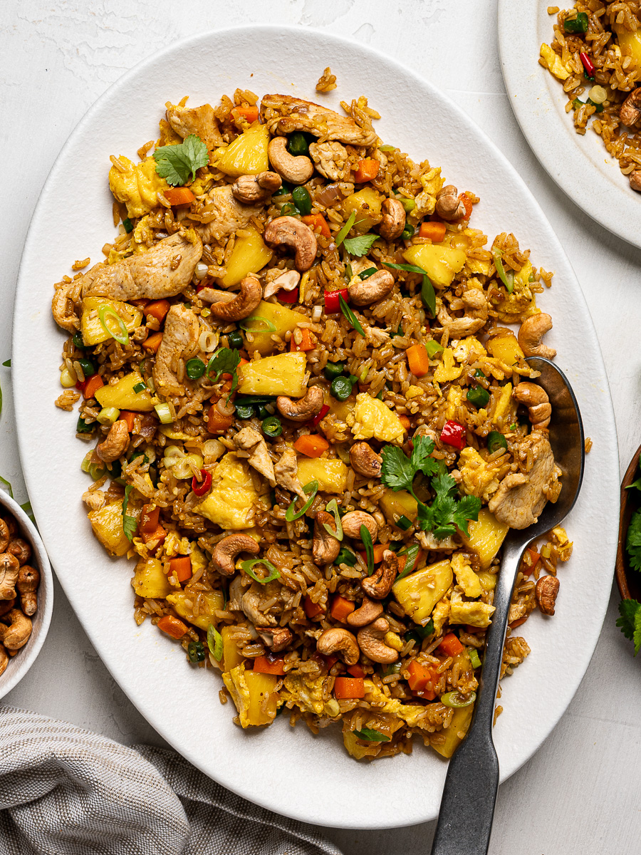 Thai pineapple fried rice served on a large white platter garnished with cilantro.